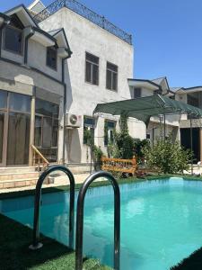 a swimming pool in front of a building at Welcome to Villa Yaaxya in Bukhara