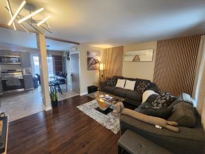 a living room with a couch and a table at Cozy 3-Bedroom Haven, Private Pool & Parking ! in Longueuil