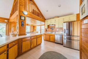 a kitchen with wooden cabinets and a stainless steel refrigerator at Just For Fun - Duck, Schooner Ridge, Pool Open 4/15, Pool Heat Option, Hot Tub, Close to Downtown in Duck
