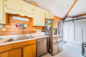 a kitchen with a sink and a refrigerator at Just For Fun - Duck, Schooner Ridge, Pool Open 4/15, Pool Heat Option, Hot Tub, Close to Downtown in Duck