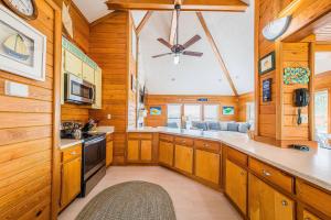 a kitchen with wooden cabinets and a ceiling fan at Just For Fun - Duck, Schooner Ridge, Pool Open 4/15, Pool Heat Option, Hot Tub, Close to Downtown in Duck +64 photos