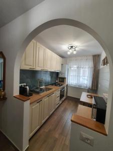 an archway in a kitchen with white cabinets and a table at BicazApart in Bicaz