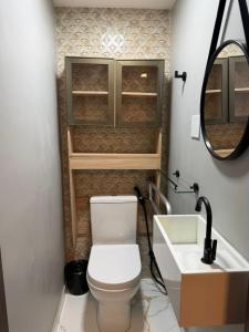 a bathroom with a toilet and a sink and a mirror at Estilo e Praticidade - Seu Flat ao lado do mar in São Luís