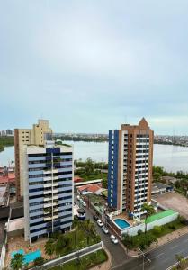 a city with tall buildings next to a river at Estilo e Praticidade - Seu Flat ao lado do mar in São Luís