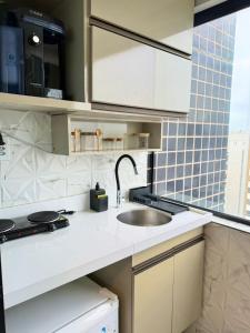 a kitchen with a sink and a counter top at Estilo e Praticidade - Seu Flat ao lado do mar in São Luís