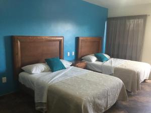 a hotel room with two beds with blue walls at Hotel Vista Verde in Huichihuayán +70 photos