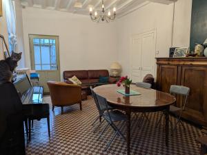 a living room with a table and a cat in a room at Le Tintamarre - Chambres et suite familiale à 5 min du Zoo de Beauval in Saint-Aignan