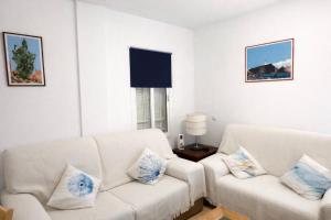 a living room with two white couches and a window at Cala Rajá 5 in La Isleta del Moro