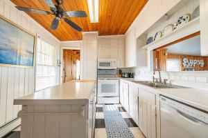 a kitchen with white cabinets and a ceiling fan at Gypsea Rose - Southern Shores, Oceanfront, Ocean View, Hot Tub, Pets OK, Flex Stays in Southern Shores +48 photos