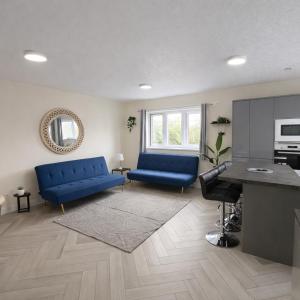 a living room with blue couches and a table at Modern Comfort for Longer Stays in Bury, 2-Bedrooms in Walmersley