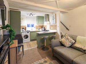 a living room with a couch and a kitchen at 21 Entry Lane in Kendal