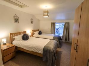 a bedroom with two beds and a window at 21 Entry Lane in Kendal