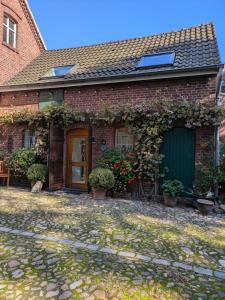 a brick house with a green door and plants at Ferienwohnung Bauernhofromantik in Raesfeld