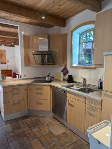 a kitchen with wooden cabinets and a sink and a window at Ferienwohnung Bauernhofromantik in Raesfeld