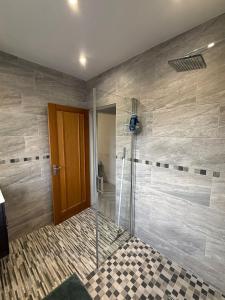 a bathroom with a shower with a glass door at Modern Comfort for Longer Stays in Bury, 2-Bedrooms in Walmersley