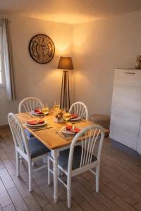 a dining room table with chairs and a whiteboard at Chambre d'Hotes Les Hortensias in Rang-du-Fliers