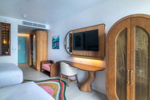 a living room with a table and a tv in a room at Hotel Indigo Bridgetown Barbados by IHG in Bridgetown