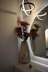 a vase with flowers sitting on a table in front of a mirror at Olympian Gods apartments in Alikanas +32 photos