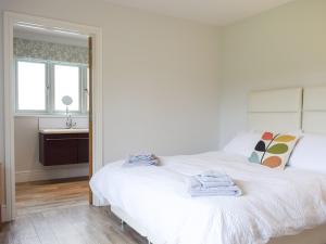 a white bed in a room with a sink at Lovells Barn in Welland +13 photos