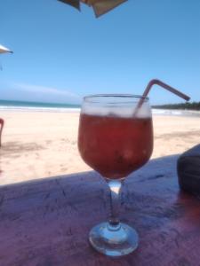 a drink in a glass sitting on a table near the beach at Pousada Santa Adélia - Boipeba BA in Ilha de Boipeba +110 photos