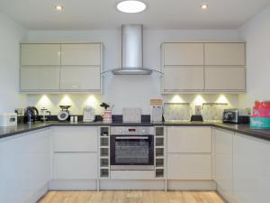 a kitchen with white cabinets and a stove at Lovells Barn in Welland