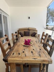 a wooden table with a plate of flowers on it at Tremendo Beachfront Apartment in Kiwengwa