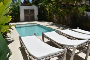 a pair of chairs and a swimming pool at Tremendo Beachfront Apartment in Kiwengwa