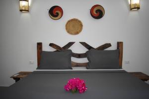 a bedroom with a bed with a pink flower on it at Tremendo Beachfront Apartment in Kiwengwa