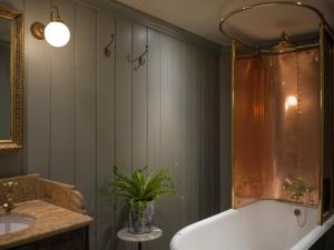 a bathroom with a tub and a sink and a plant at Batty Langley's in London +102 photos