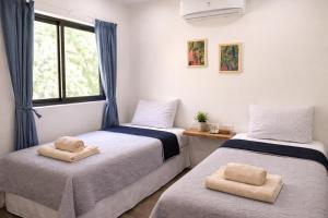 two beds in a room with a window at Las Naveiras in Tamarindo +33 photos