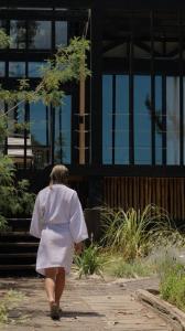 a woman walking down a sidewalk in front of a building at Surf Lodge Punta de Lobos in Pichilemu