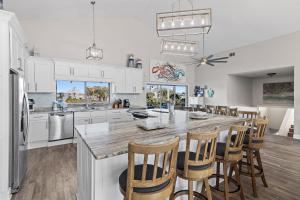 a kitchen with a large kitchen island with wooden chairs at Sea-Esta in Destin