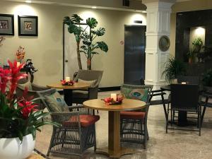 um restaurante com duas mesas, cadeiras e plantas em GreenTree Inn & Suites Los Angeles - Alhambra - Pasadena em Alhambra