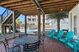 a patio with a table and chairs and a pool at Sea-Esta in Destin