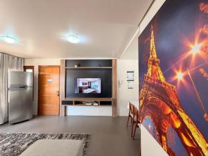 a living room with a painting of the eiffel tower at Apartamento Coração de Gramado in Gramado