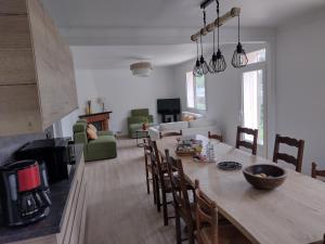 a kitchen and living room with a wooden table and chairs at Gite des Noës in Lamballe Armor