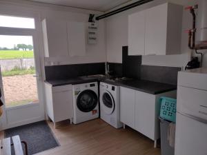 a kitchen with a washing machine and a washer at Gite des Noës in Lamballe Armor
