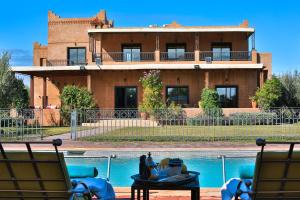 a house sitting next to a swimming pool with a house at Maison safou in Marrakesh
