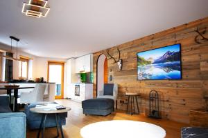 a living room with a tv on a wooden wall at Premium Apartment Grischuna 1-8 Pers in Klosters