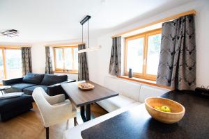 a living room with a couch and a table at Premium Apartment Grischuna 1-8 Pers in Klosters +24 photos
