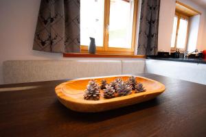 a wooden bowl with pine cones on top of a table at Premium Apartment Grischuna 1-8 Pers in Klosters