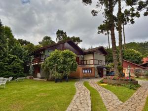 a large house with a tree in the yard at Casa Garten by Concavus in Campos do Jordão