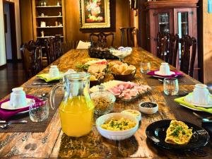 a table with food and orange juice on it at Casa Garten by Concavus in Campos do Jordão