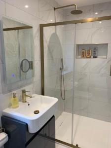 a white bathroom with a sink and a shower at Park View Guest Suite in South Milford