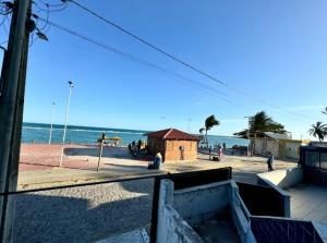 a view of a beach with a building and the ocean at Barrah flat in Barra de São Miguel