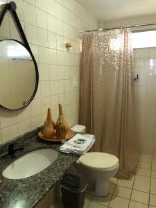 a bathroom with a sink and a toilet and a shower at Barrah flat in Barra de São Miguel +7 photos