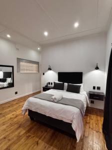 a bedroom with a large bed and two lights at Cradock Guest House & Self Catering in Cradock