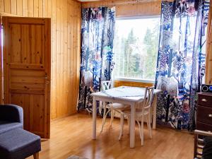 a dining room with a table and chairs and a window at Kätkävaara Wilderness Lodge in Muurola