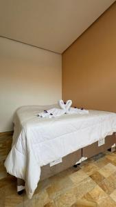 a bed with white sheets and towels on it at Cantinho dos Pássaros Centro Penedo RJ in Penedo +7 photos