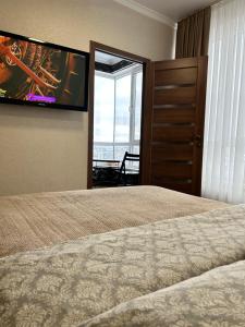 a bedroom with a bed and a flat screen tv at Gold in Chişinău